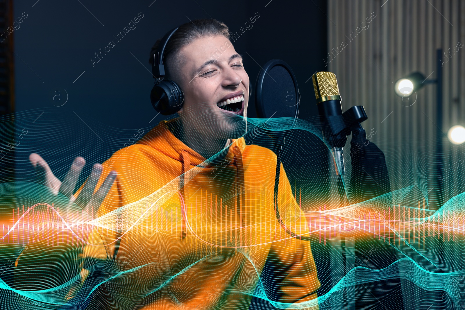 Image of Man with headphones singing into microphone in professional record studio. Sound waves