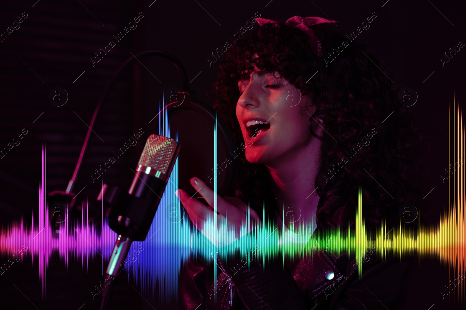 Image of Vocalist singing into microphone in professional record studio. Sound waves