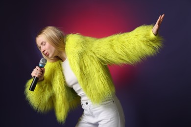 Talented singer in faux fur performing on dark background with pink light