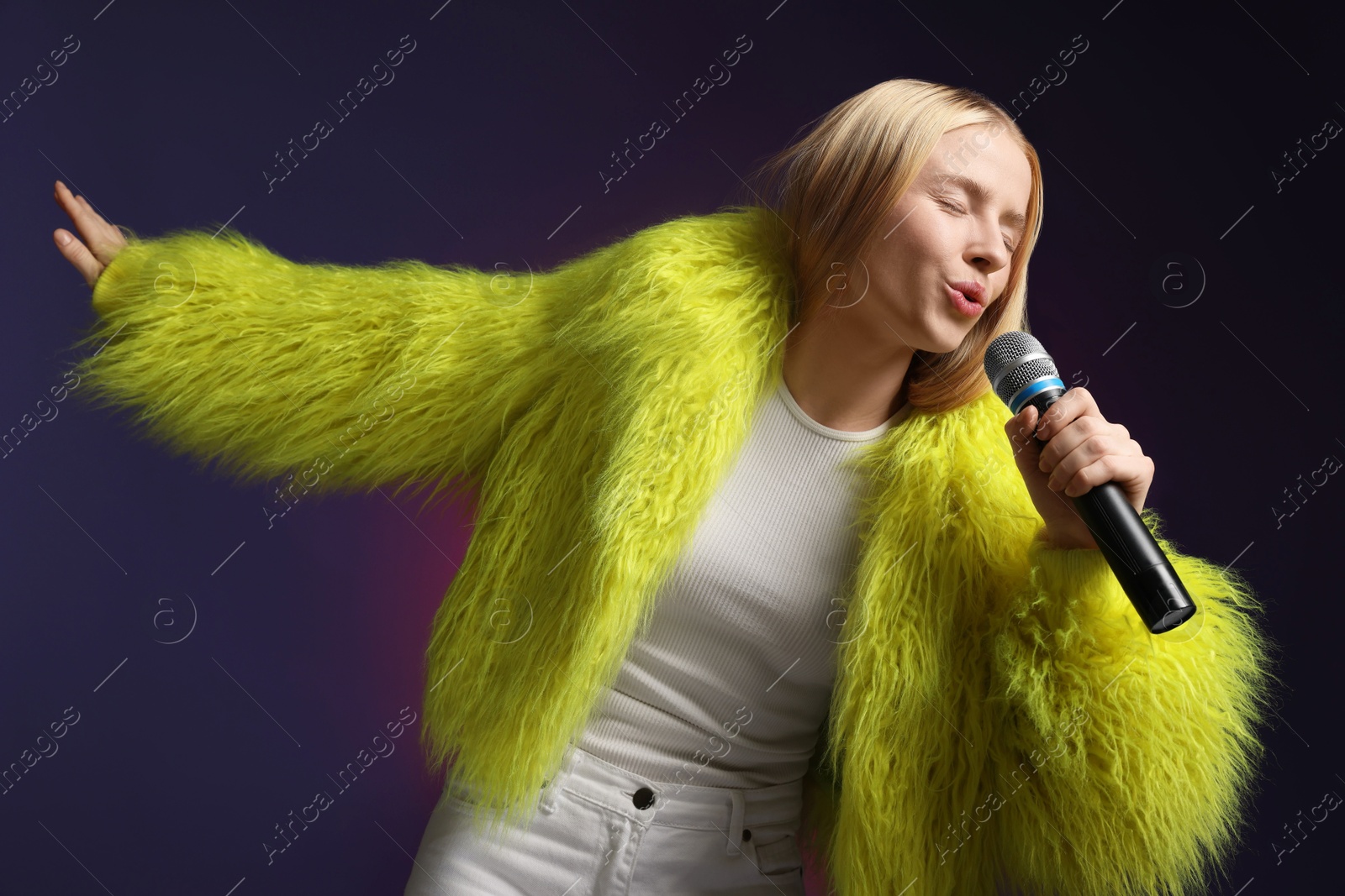 Photo of Talented singer in faux fur performing on dark background