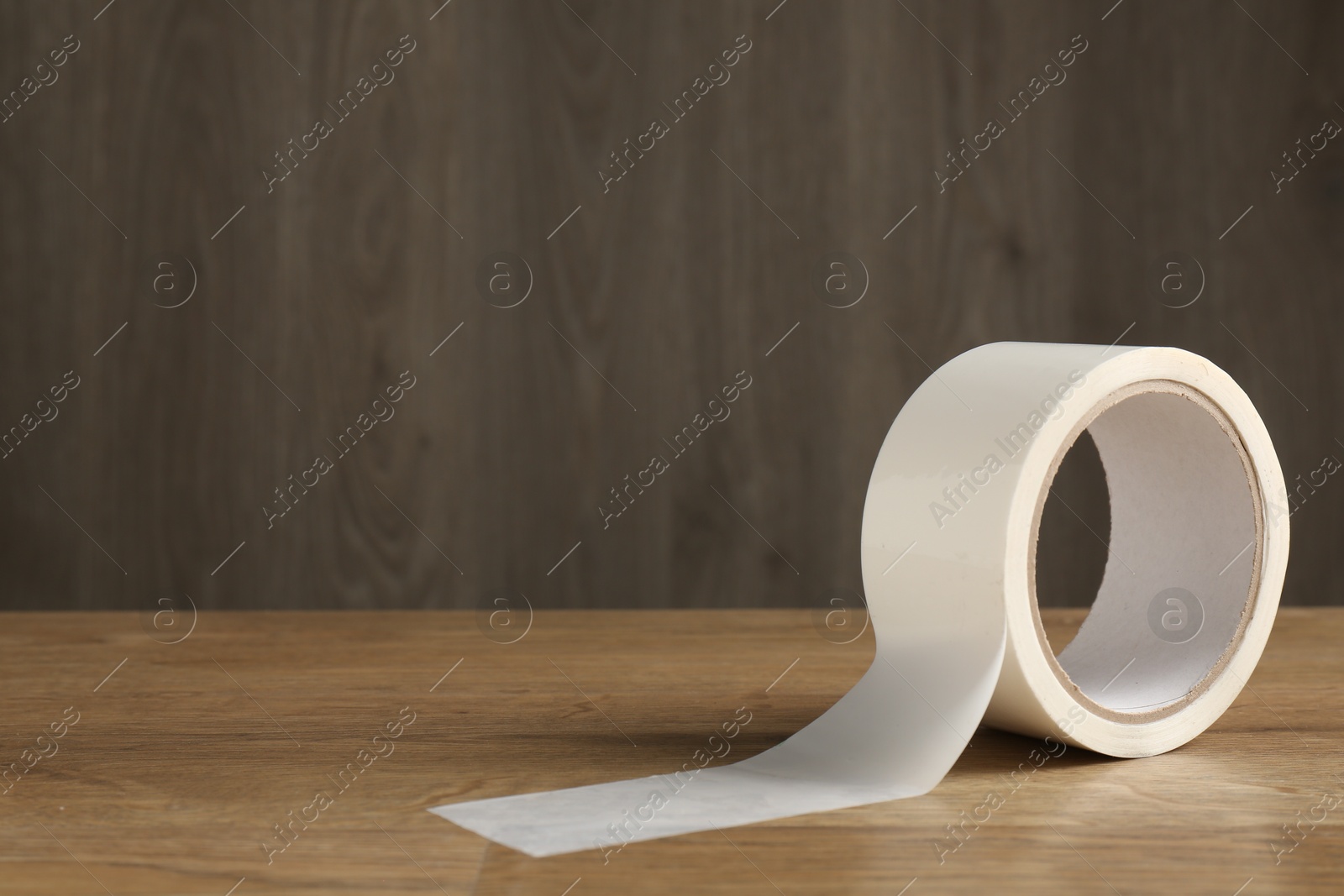 Photo of Roll of masking tape on wooden table, space for text