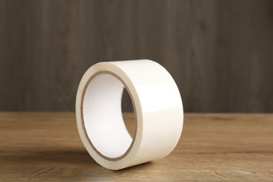 Roll of masking tape on wooden table, closeup