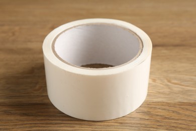 Roll of masking tape on wooden table, closeup