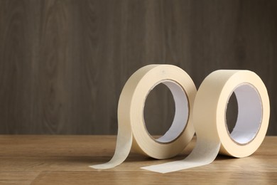 Rolls of masking tape on wooden table, space for text