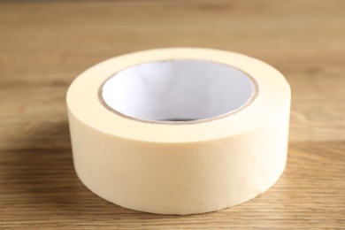 Roll of masking tape on wooden table, closeup