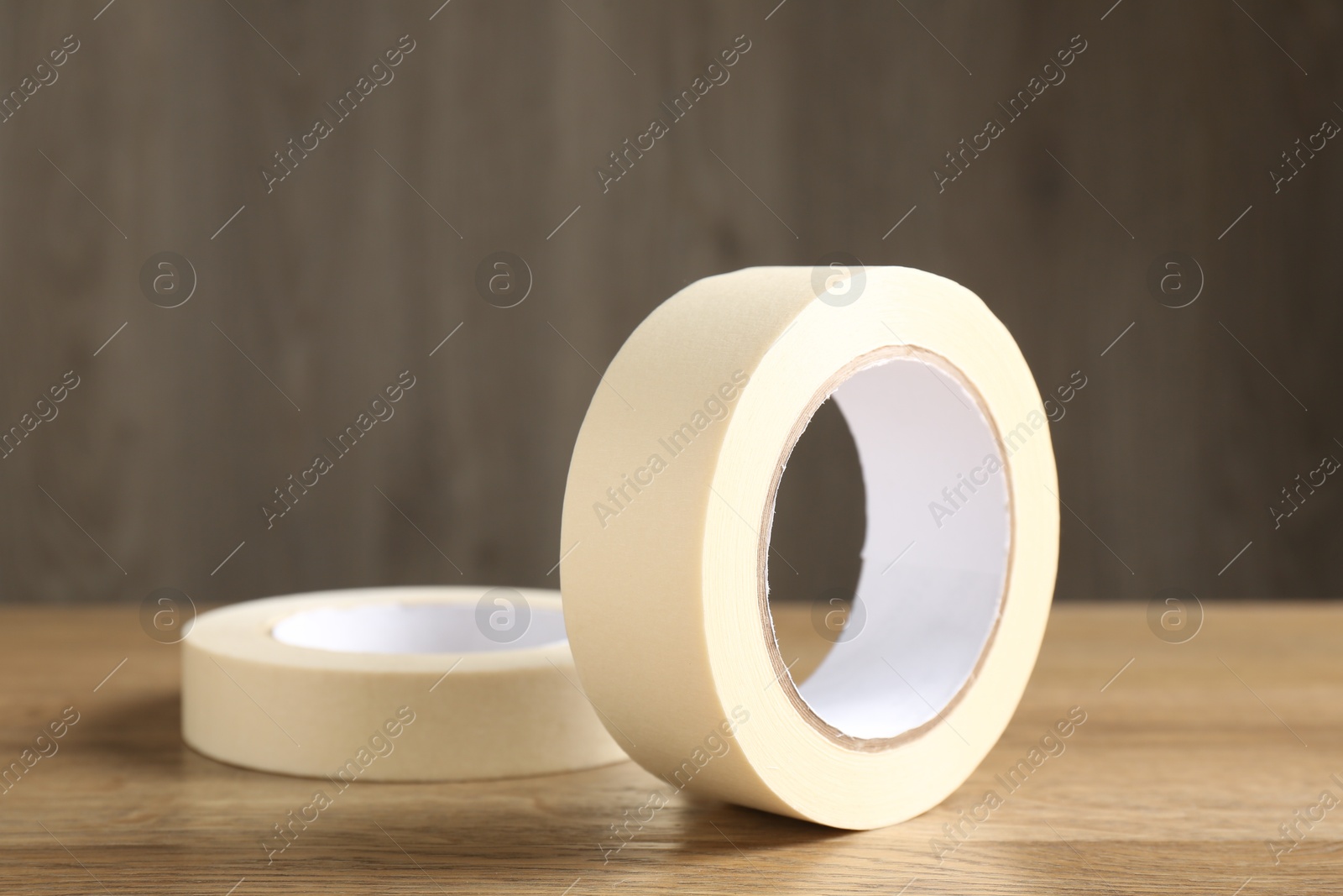 Photo of Rolls of masking tape on wooden table, closeup