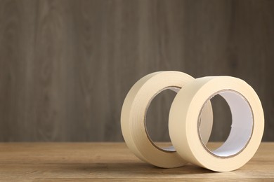 Photo of Rolls of masking tape on wooden table, space for text