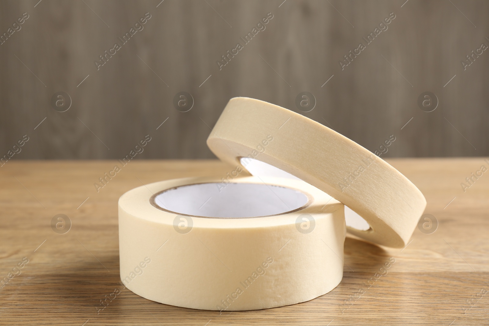 Photo of Rolls of masking tape on wooden table, closeup