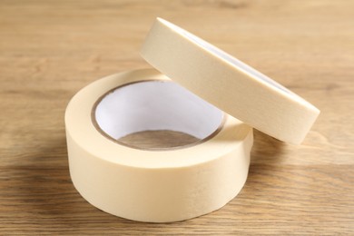 Photo of Rolls of masking tape on wooden table, closeup