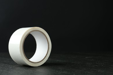 Photo of Roll of masking tape on black table, space for text