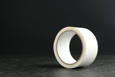 Photo of Roll of masking tape on black table, space for text