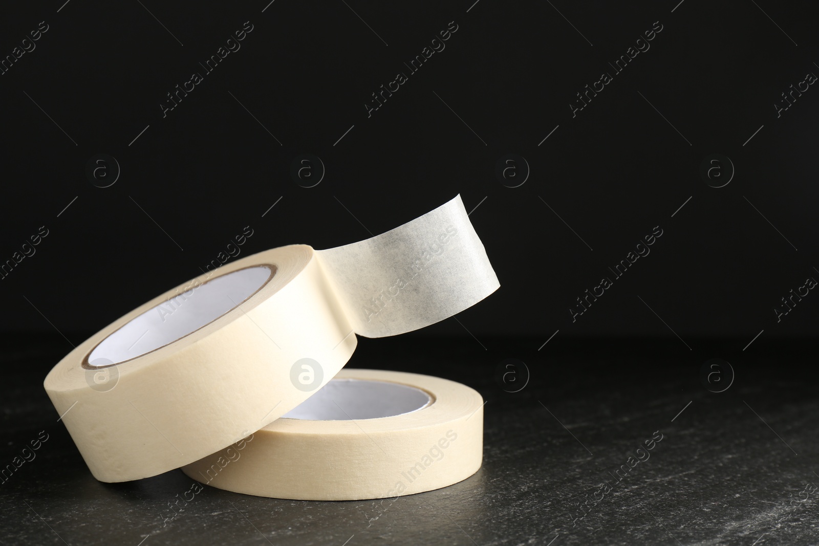 Photo of Rolls of masking tape on black table, space for text