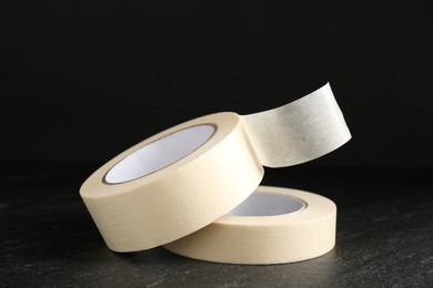 Photo of Rolls of masking tape on black table, closeup