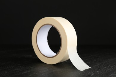 Photo of Roll of masking tape on black table