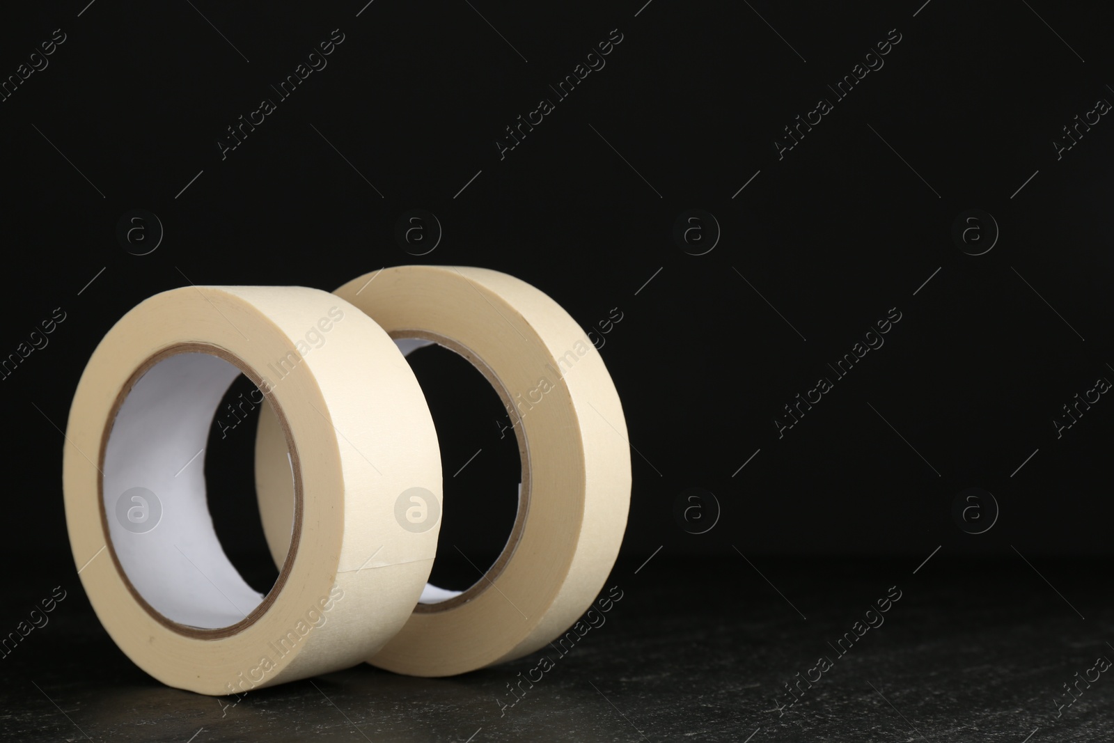 Photo of Rolls of masking tape on black table, space for text