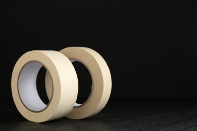 Photo of Rolls of masking tape on black table, space for text