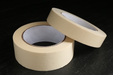 Photo of Rolls of masking tape on black table, closeup