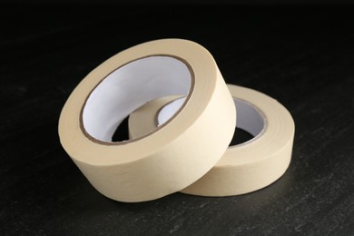 Photo of Rolls of masking tape on black table, closeup