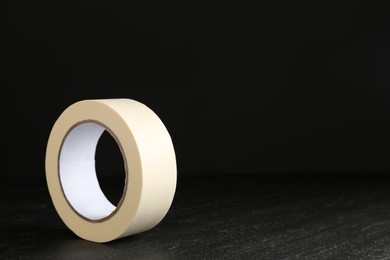 Photo of Roll of masking tape on black table, space for text