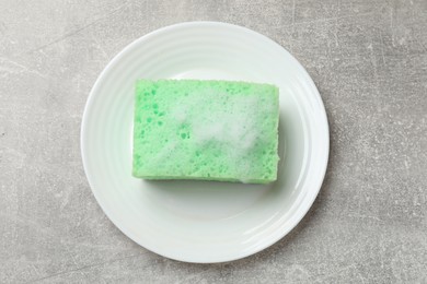 Photo of Sponge with foam and plate on light grey table, top view