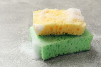 Photo of Sponges and foam on light grey table, closeup