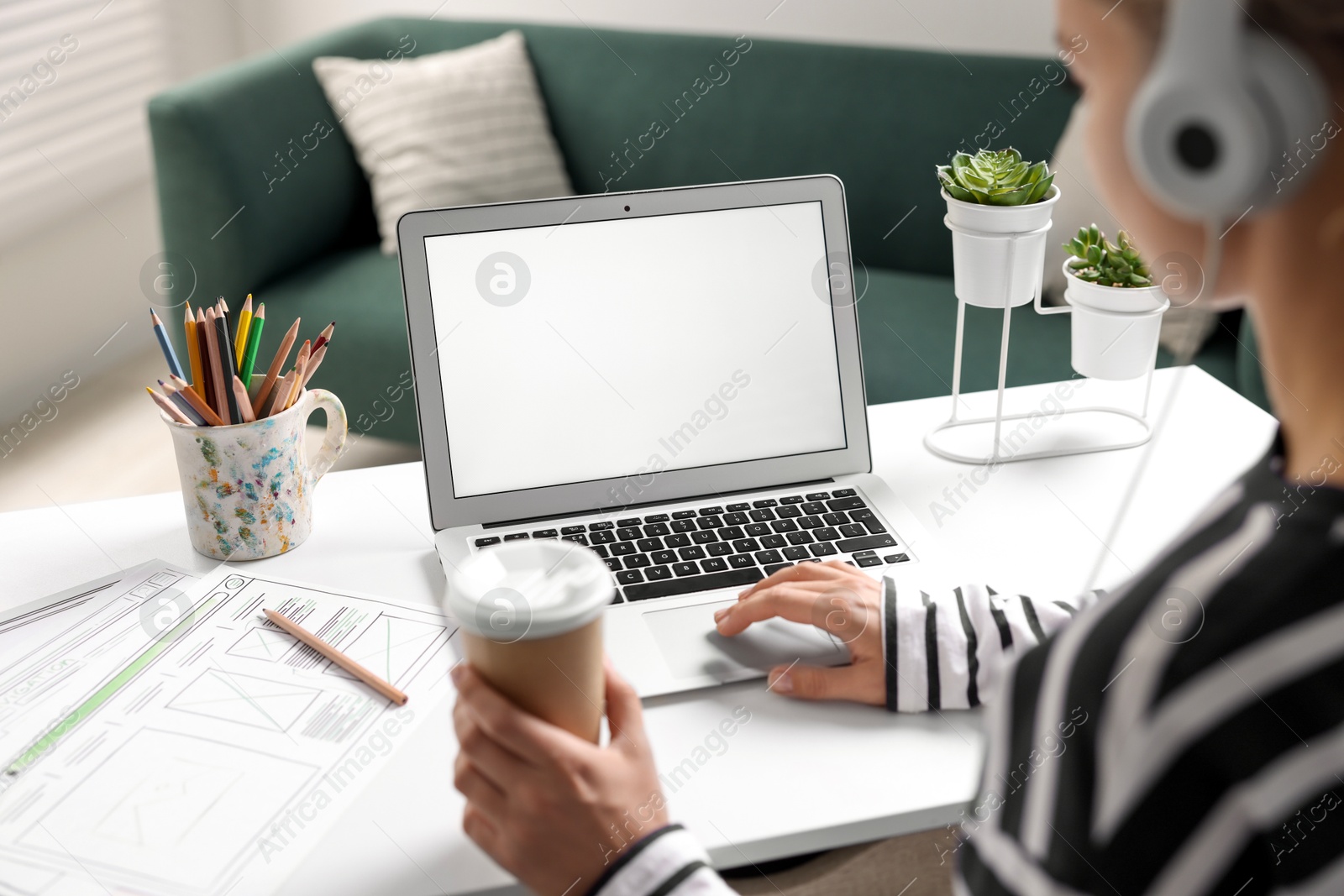 Photo of Woman working with laptop at table in office, closeup. Mockup for design