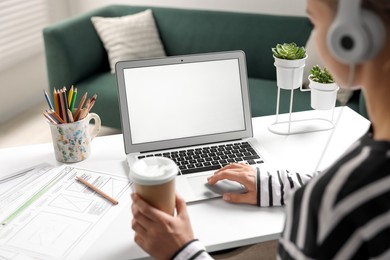 Photo of Woman working with laptop at table in office, closeup. Mockup for design