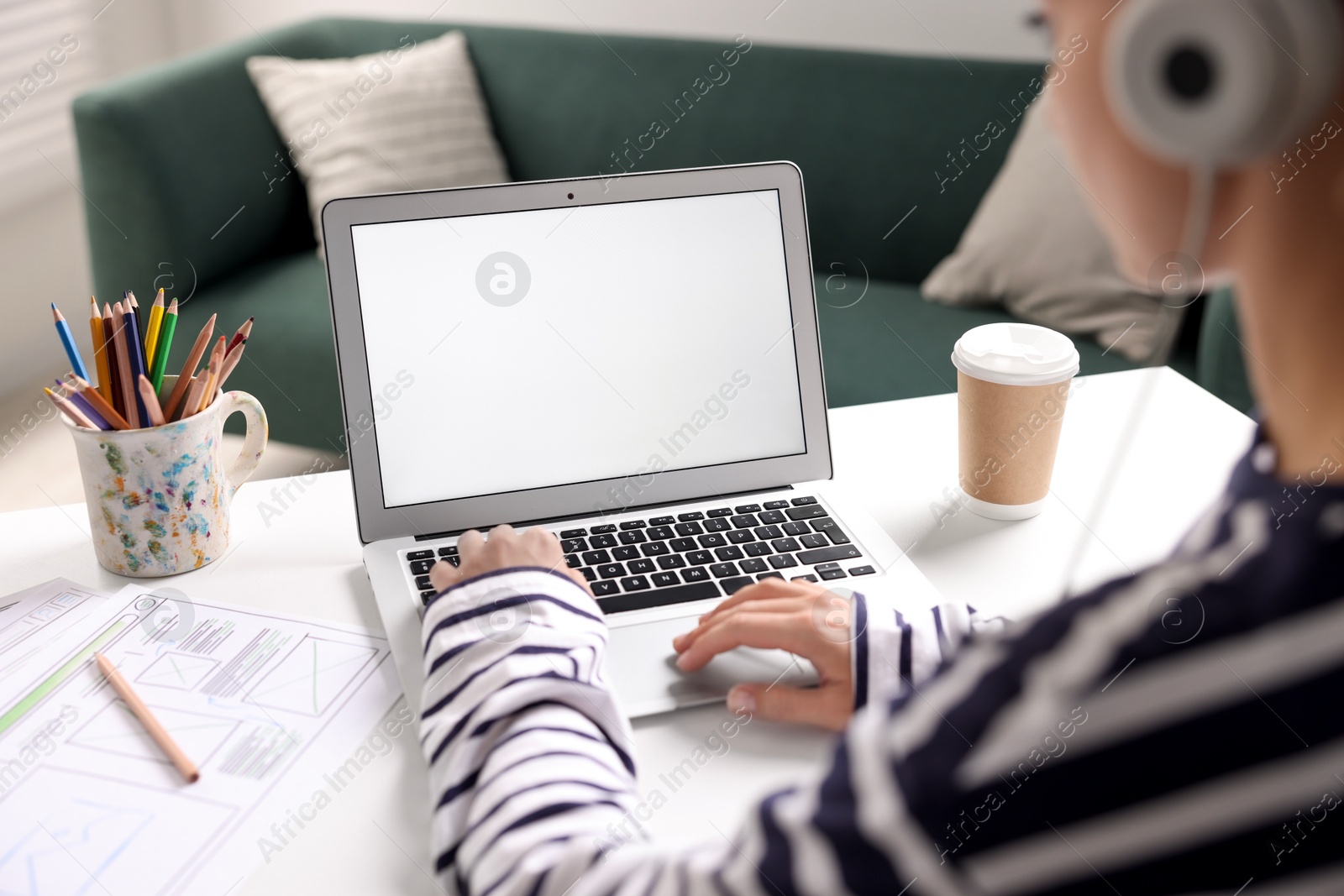 Photo of Woman working with laptop at table in office, closeup. Mockup for design