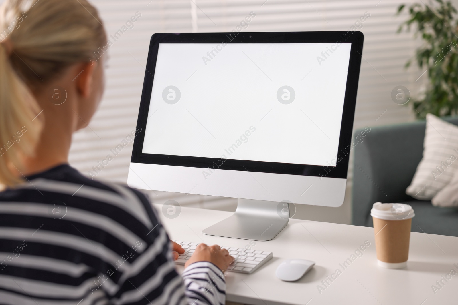 Photo of Woman working with computer monitor at table in office. Mockup for design