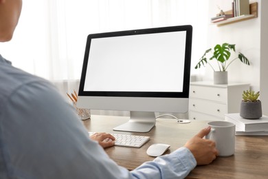 Woman working with computer monitor at wooden table in office, closeup. Mockup for design