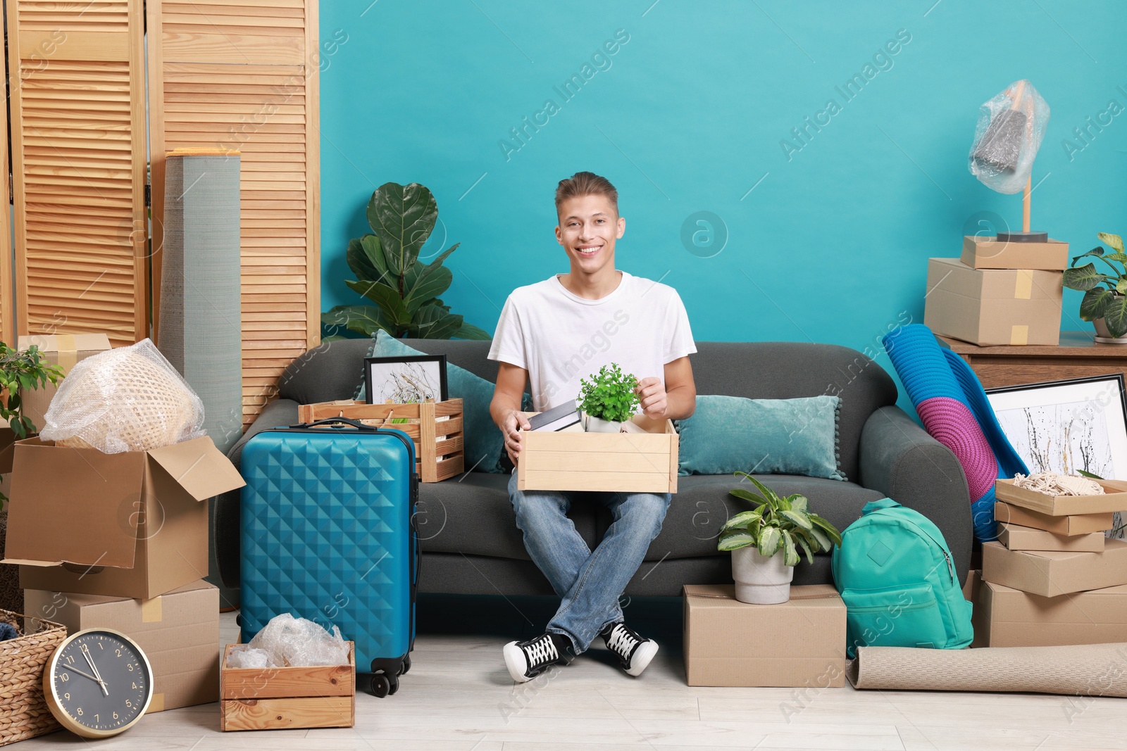 Photo of Happy man with different stuff in new apartment. Housewarming party