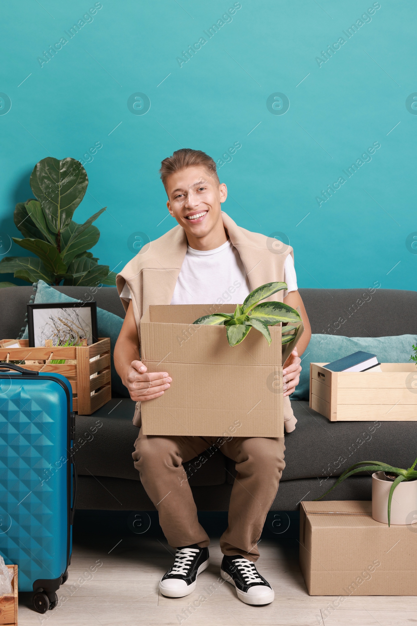 Photo of Happy man with different stuff in new apartment. Housewarming party