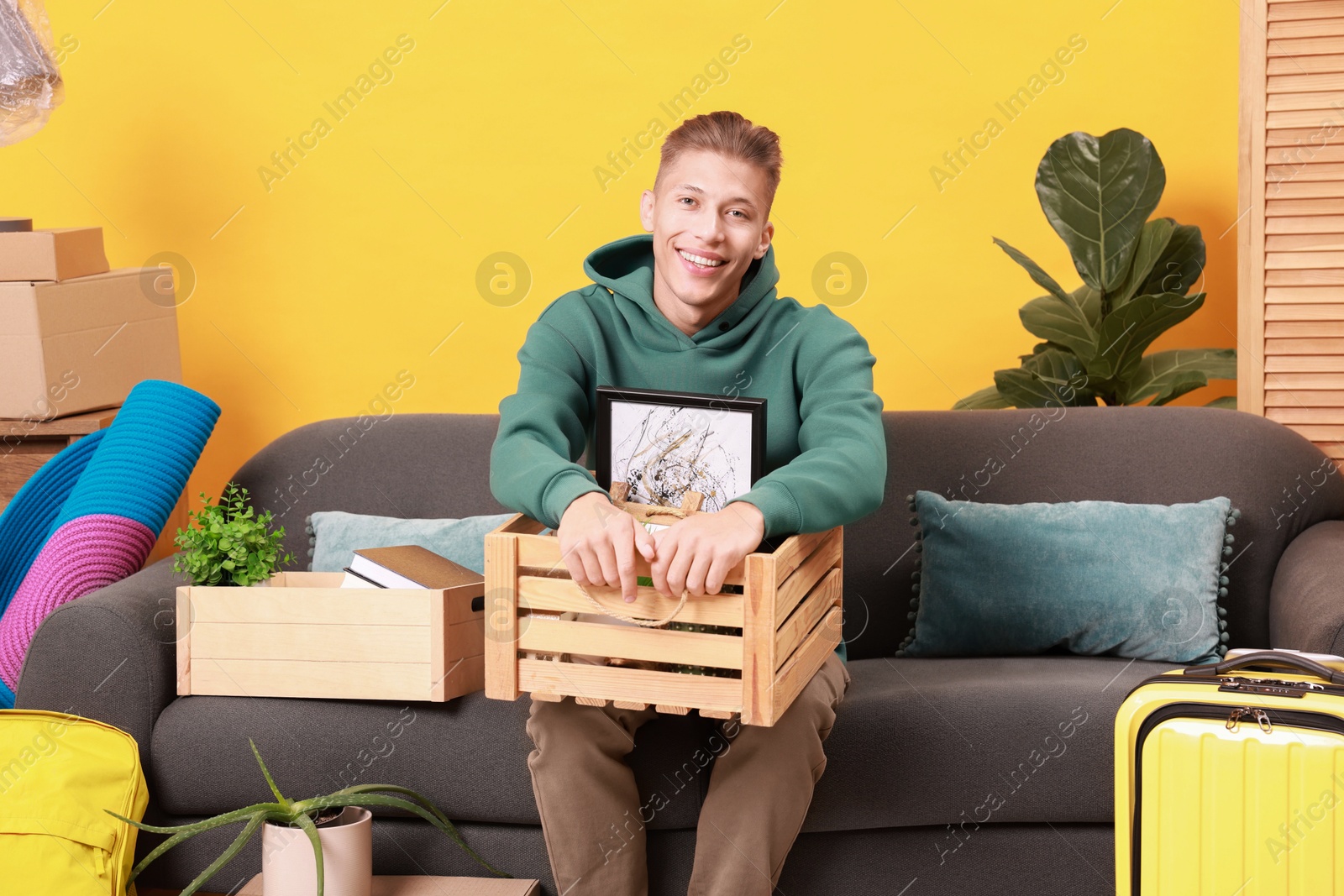 Photo of Happy man with different stuff in new apartment. Housewarming party