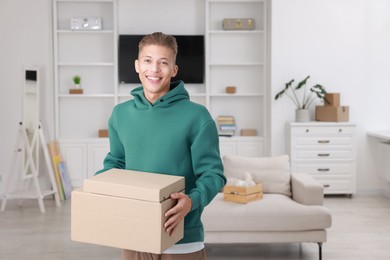 Photo of Happy man with moving boxes in new apartment. Housewarming party