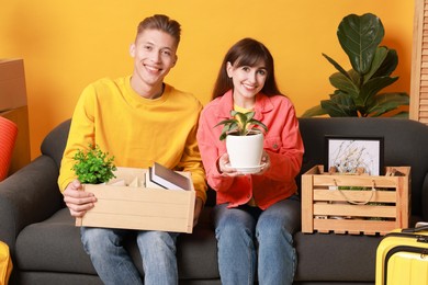 Photo of Happy couple with different stuff in new apartment. Housewarming party