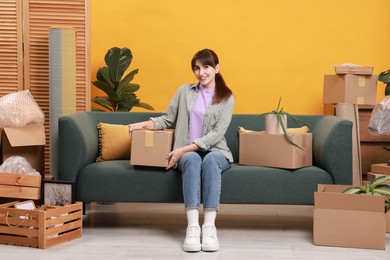 Photo of Happy woman with moving boxes in new apartment. Housewarming party