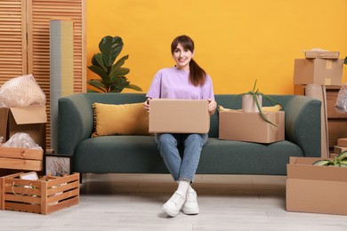 Photo of Happy woman with moving boxes in new apartment. Housewarming party