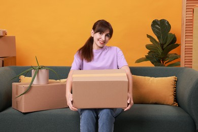 Photo of Happy woman with moving boxes in new apartment. Housewarming party