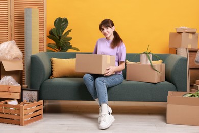 Photo of Happy woman with moving boxes in new apartment. Housewarming party