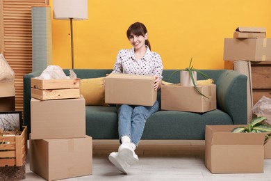 Happy woman with moving boxes in new apartment. Housewarming party