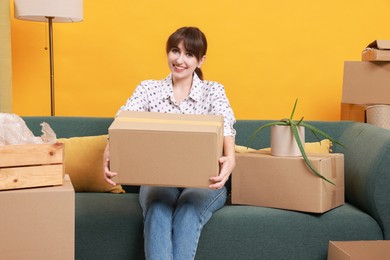 Photo of Happy woman with moving boxes in new apartment. Housewarming party