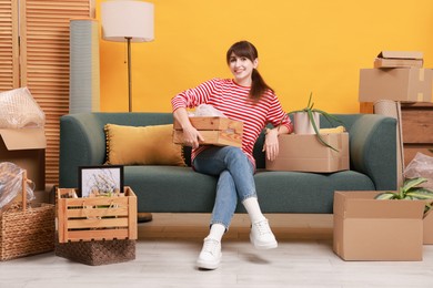 Photo of Happy woman with moving boxes in new apartment. Housewarming party