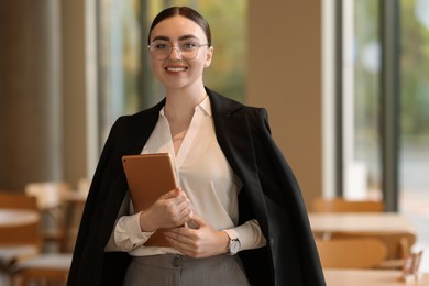 Woman in stylish formal suit with tablet indoors