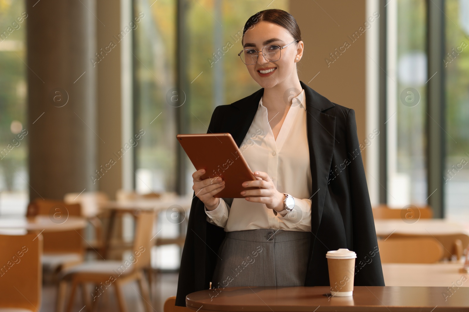 Photo of Woman in stylish formal suit with tablet indoors