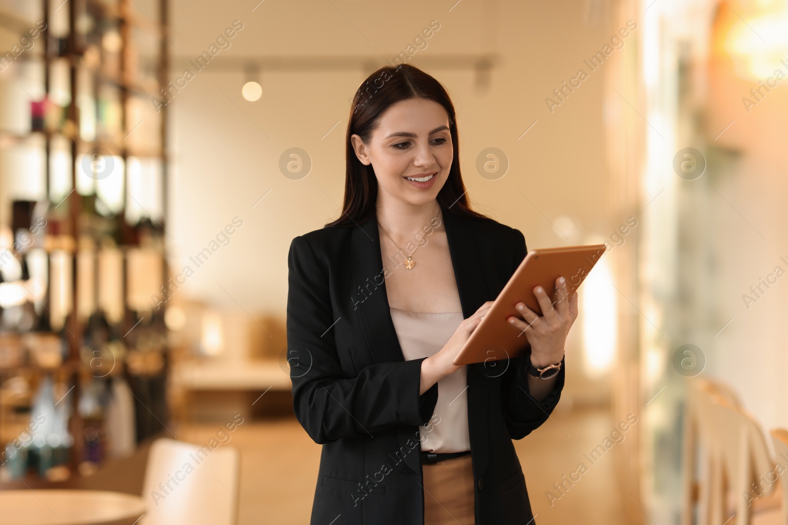 Photo of Woman in stylish formal suit with tablet indoors