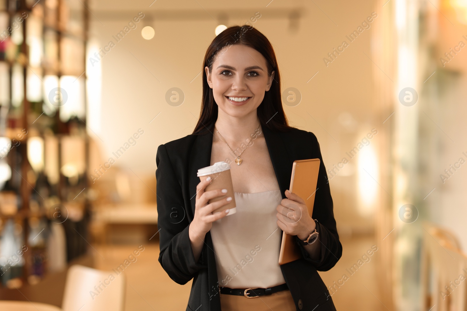 Photo of Woman in stylish formal suit with tablet and coffee indoors