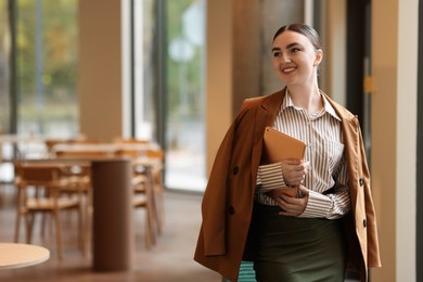 Photo of Woman in stylish formal suit with tablet indoors. Space for text