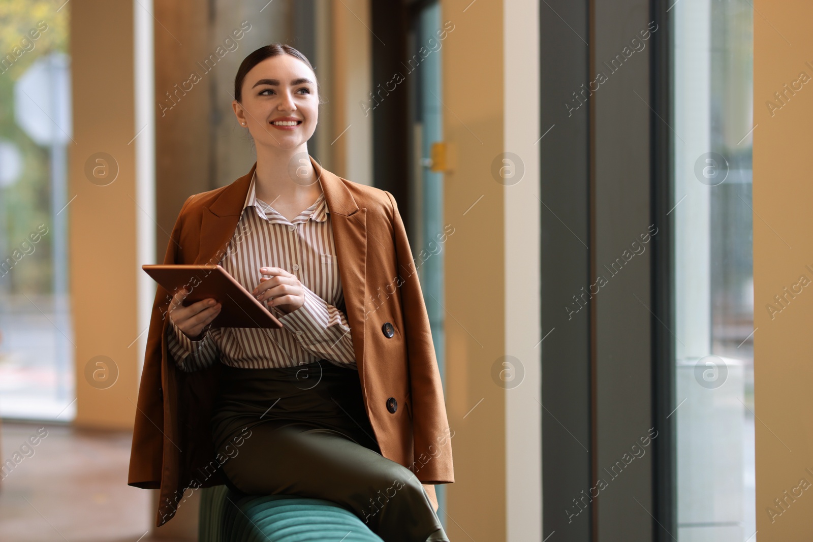 Photo of Woman in stylish formal suit with tablet indoors. Space for text