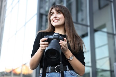 Photo of Professional photographer with digital camera near building outdoors