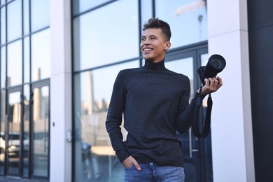 Photo of Professional photographer with camera near building outdoors. Space for text